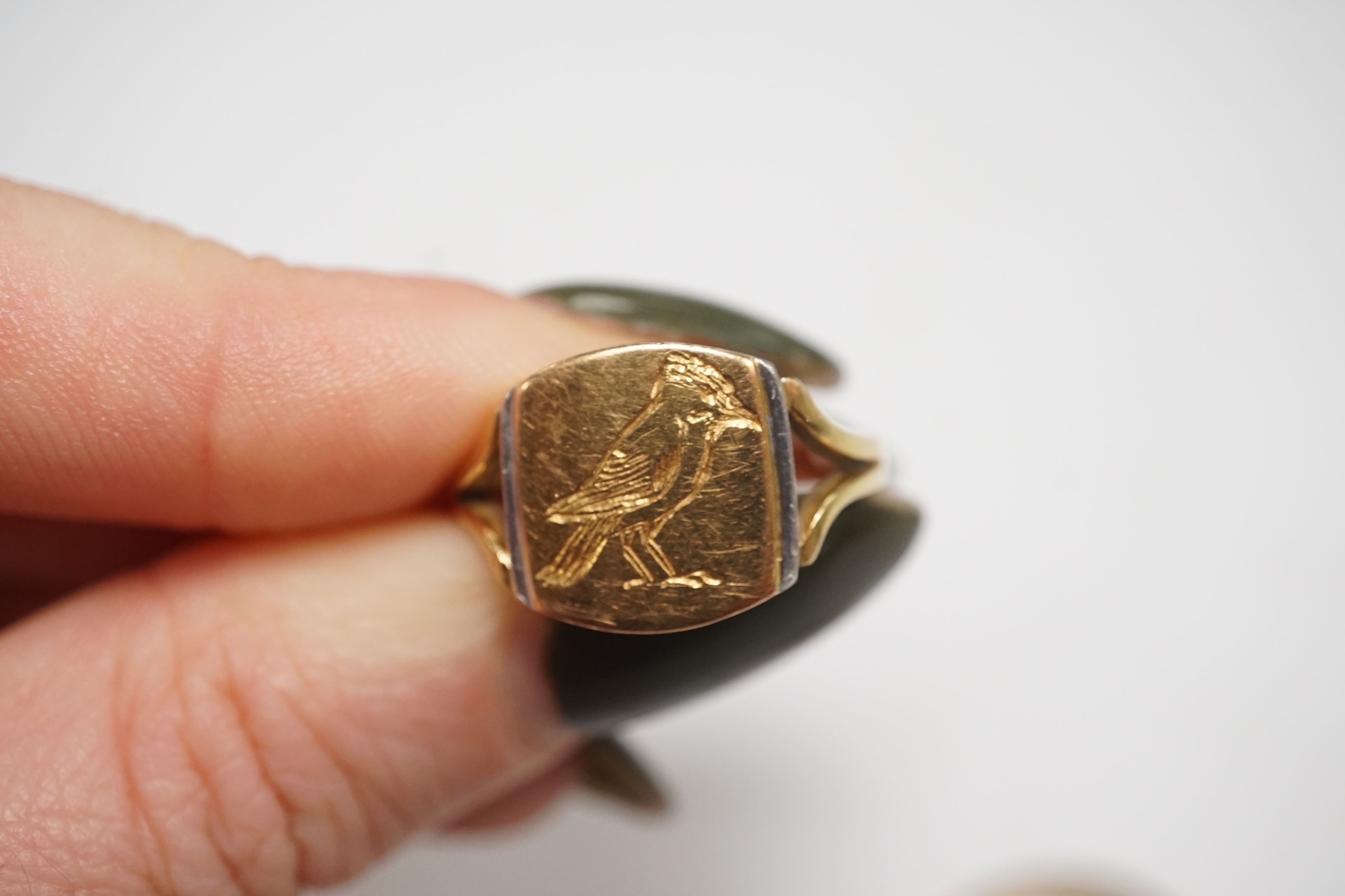 A yellow metal and intaglio agate set oval ring, size P, together with a modern 18ct gold signet ring, engraved with a bird, gross weight 12.3 grams. Condition - poor to fair